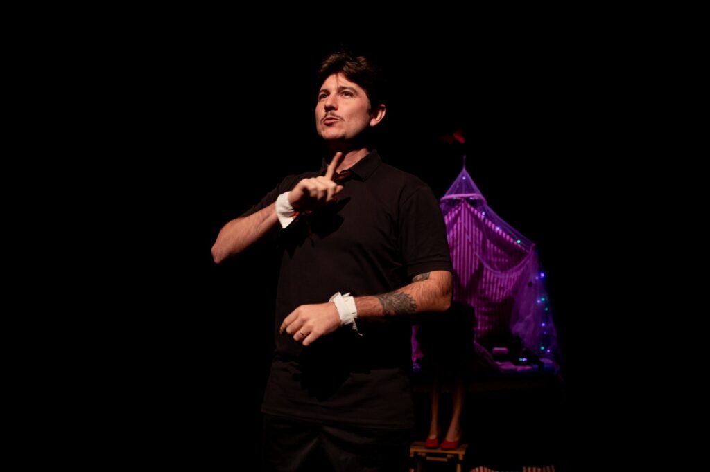 Intérprete de LIBRAS Lucas Grigio em cena no espetáculo Circo de Los Pies